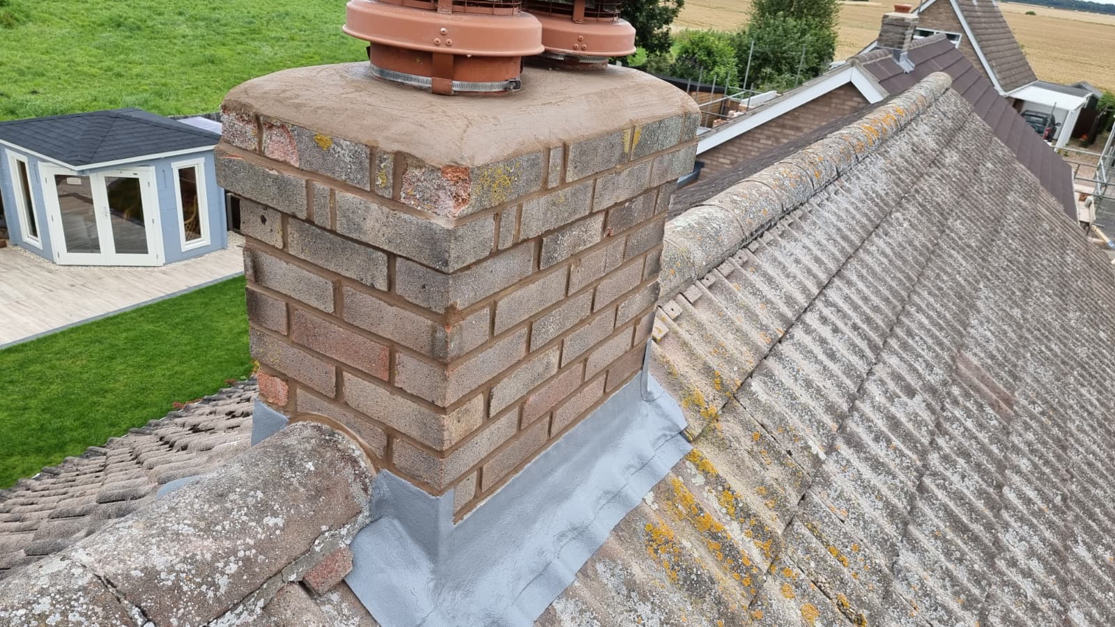 Chimney repointing and lead flashing work on a tiled roof