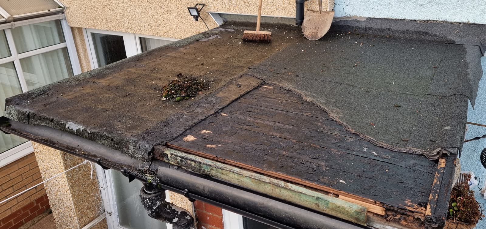 Old flat roof with deteriorated felt needing replacement