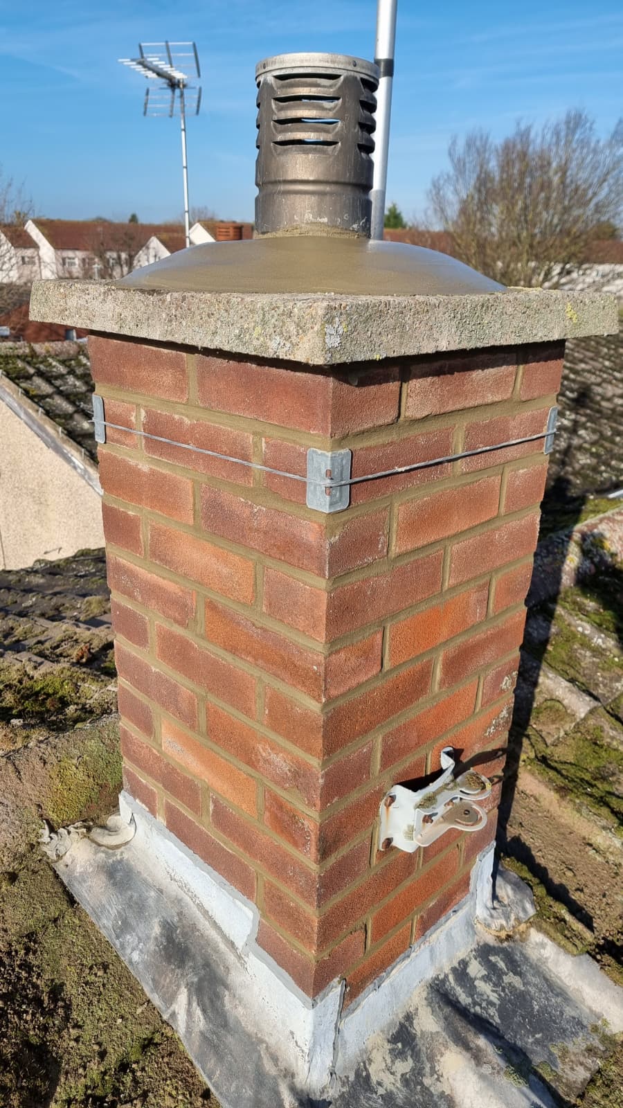 Newly repointed brick chimney with lead flashing and cowl