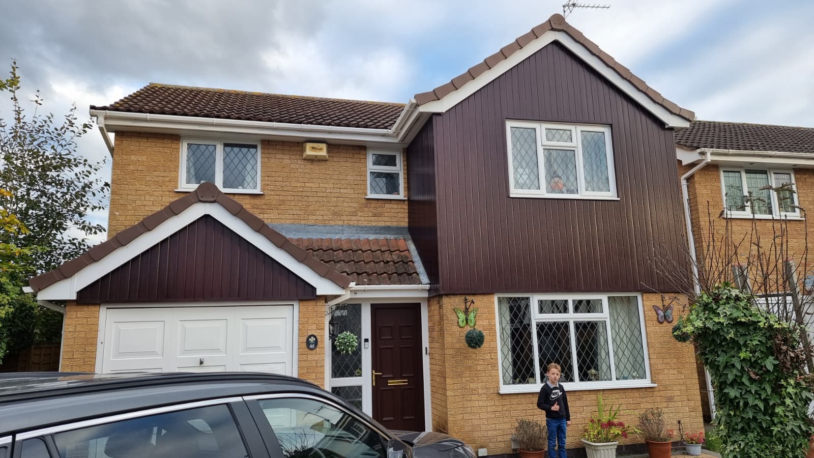 Detached house with completed brown cladding and fascia work