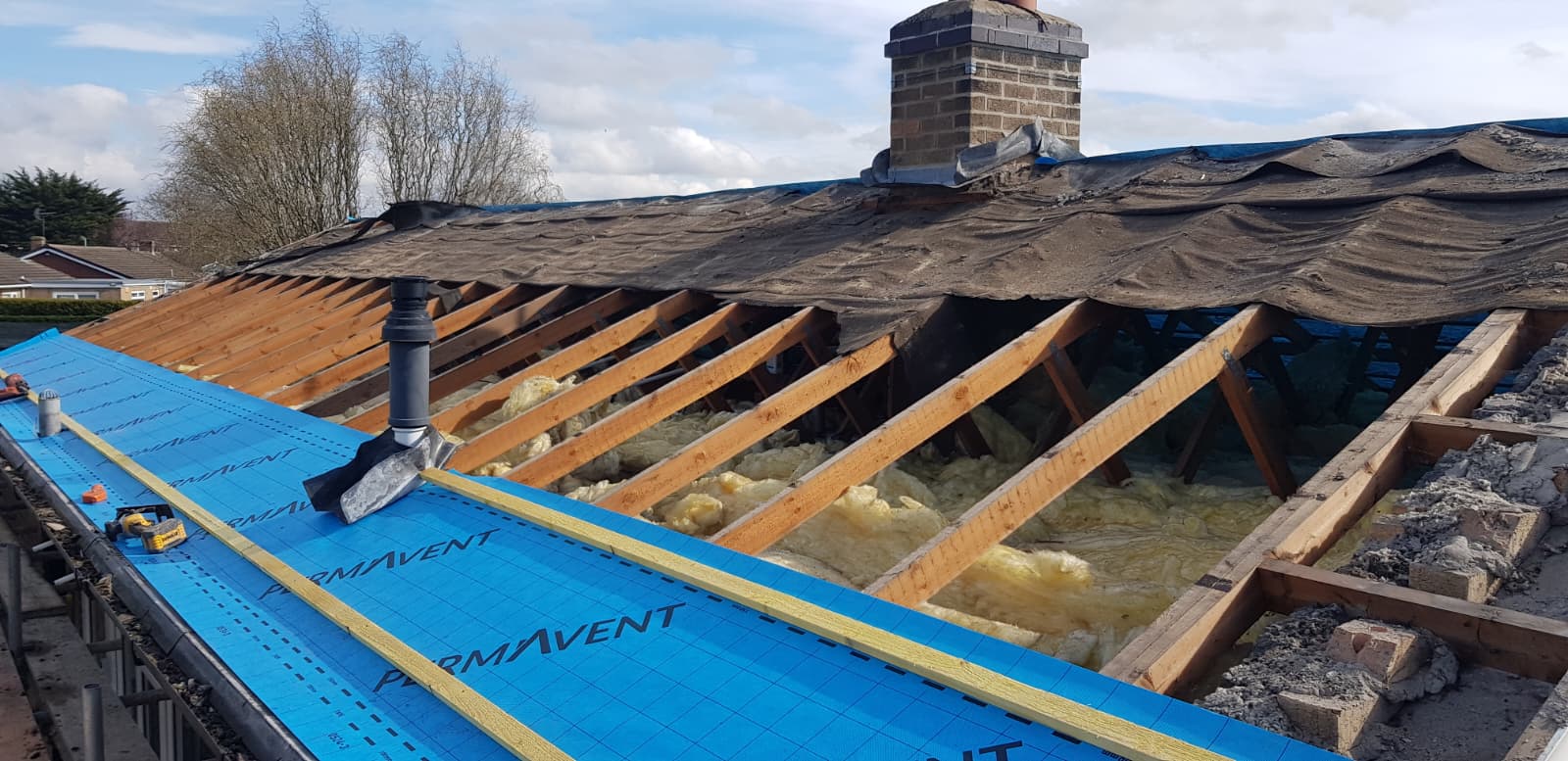 Grey concrete tiles stacked on Permavent membrane and battens ready to lay