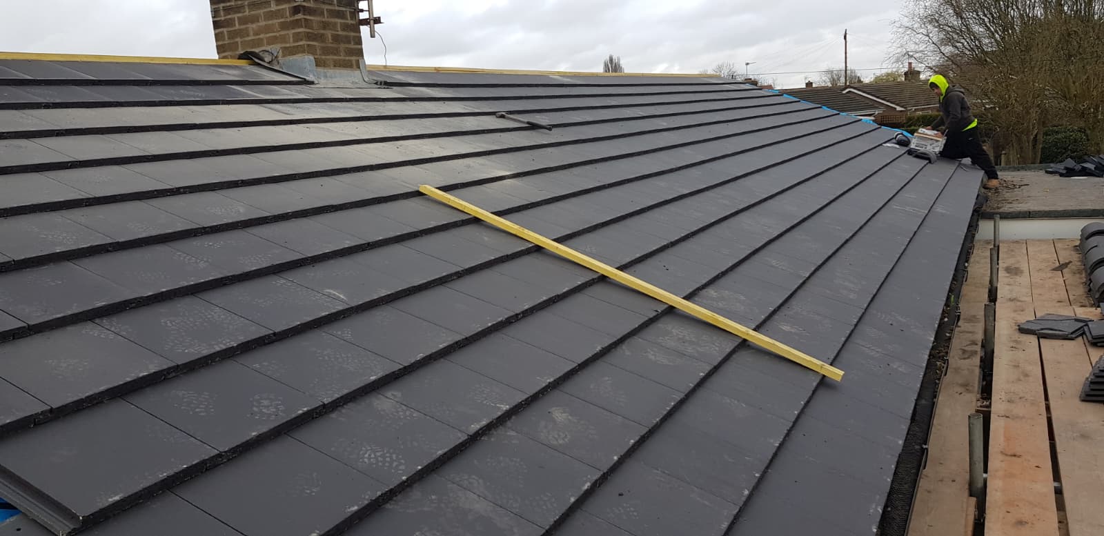 Roofer laying new tiles over Roofshield breathable membrane