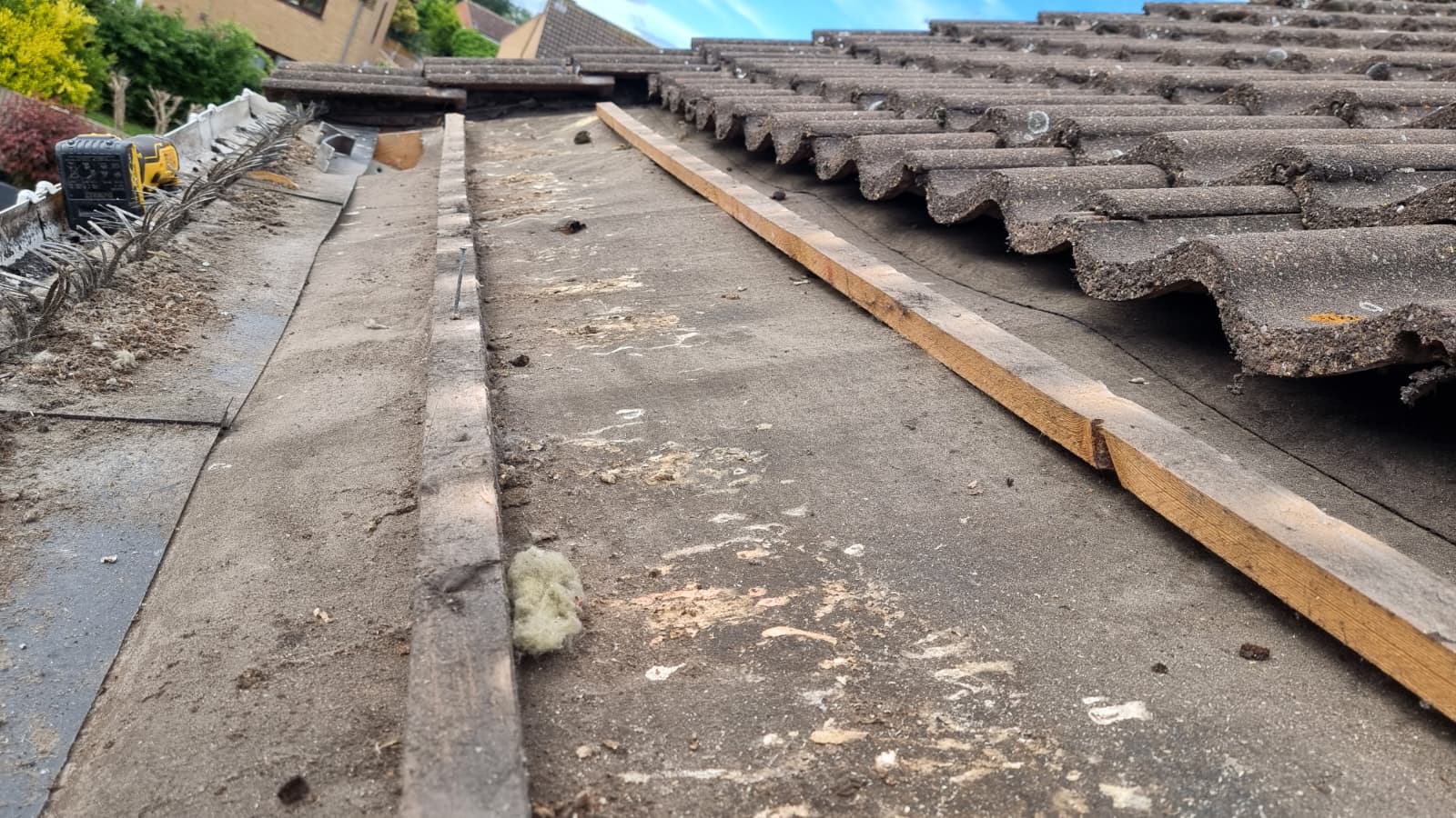 Old worn felt and battens exposed with tiles lifted during roof strip